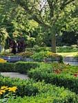 Manicured landscape with trimmed hedges, colorful flower beds, and polished greenery for Chenequa residential and commercial properties.