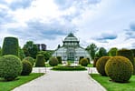 Well-maintained botanical garden with trimmed hedges and a glass greenhouse, showcasing professional landscape maintenance in Madison