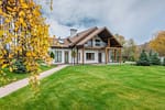 Well-maintained luxury home with a lush green lawn, manicured trees, and professional landscape maintenance by David J. Frank Landscape Contracting.