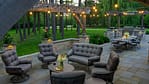 Elegant outdoor patio with comfortable seating, string lighting, and a built-in grilling area, showcasing high-quality landscape design for Mequon properties.
