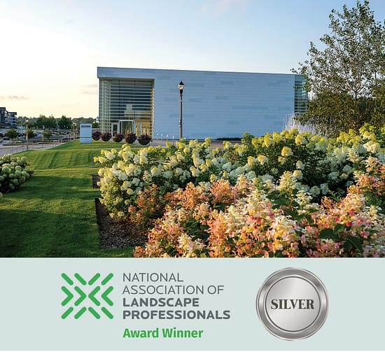Museum campus with manicured lawn and blooming hydrangea beds surrounding a modern building