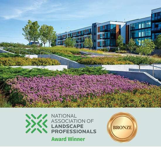 Modern apartment building with terraced native plantings and accessible concrete walkways