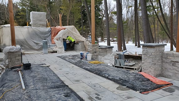 Winter landscaping project with patio and firepit built by David J. Frank Landscape Contracting