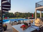 The grill master gets a great view of the pool and the park-like setting in the backyard.