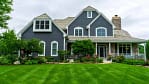 Beautifully landscaped Mequon home with lush green lawn, trimmed shrubs, and vibrant garden beds showcasing professional residential landscaping.