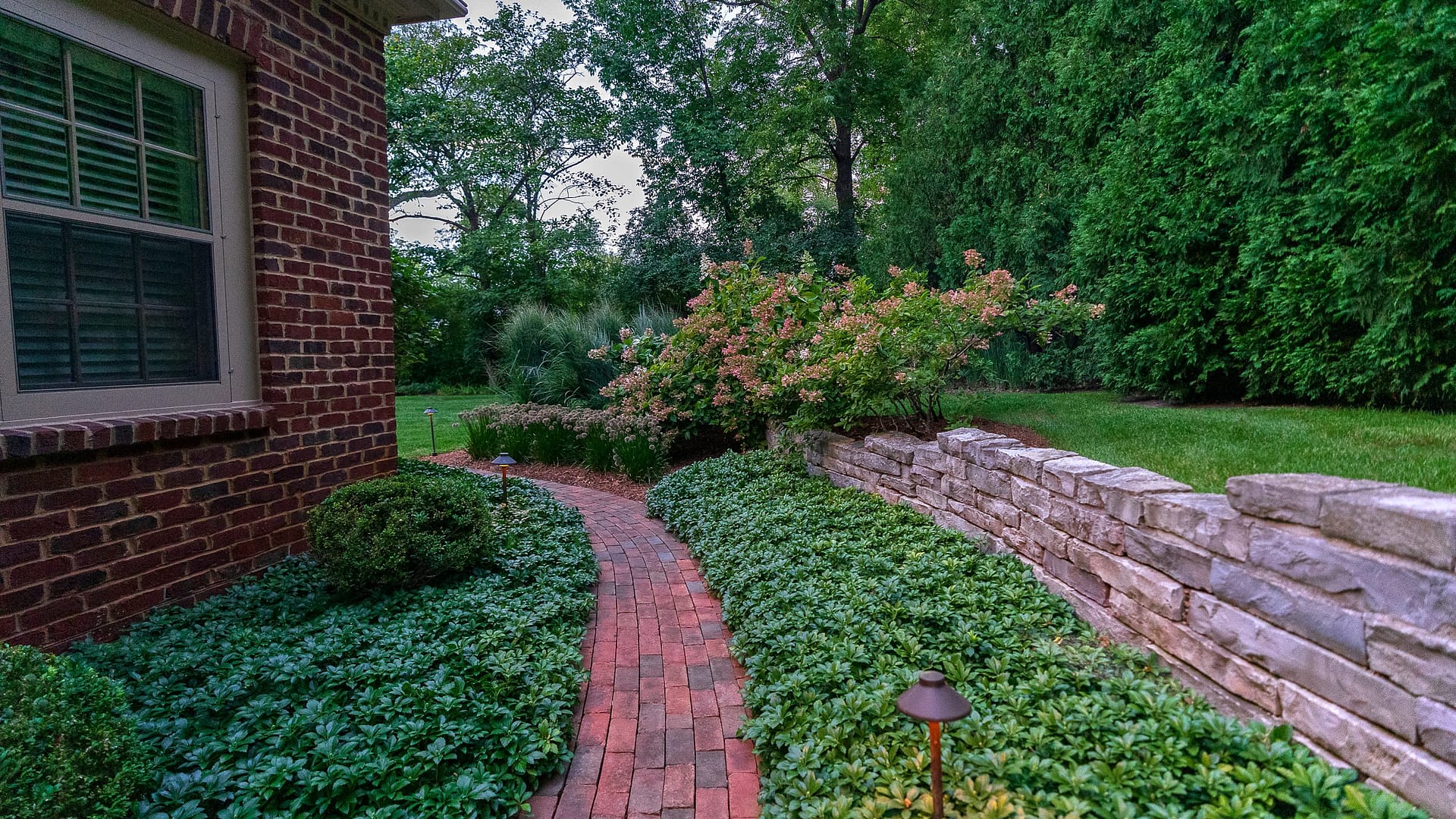 We maintain the molded red clay brick walkway alongside the house, which provides a perfect transition to backyard.